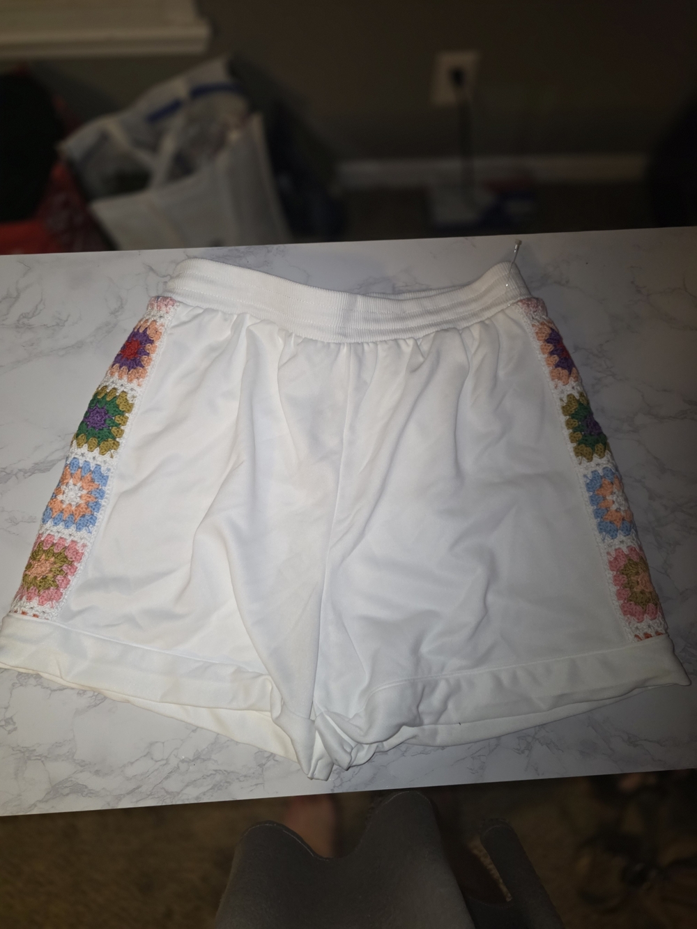 Rebellion Again white shorts with colorful crochet side panels, size Large.
